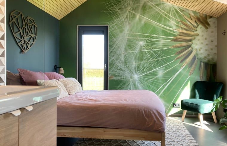 Schlafzimmer im Ferienhaus in Koudum mit einzigartiger Wandgestaltung und natuerlichem Licht.