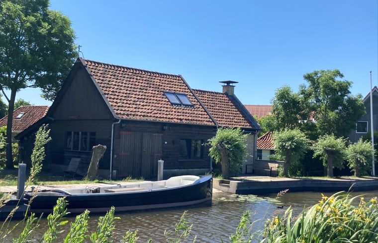 Gezellig vakantiehuis in Gaastmeer, gelegen aan de Fluessen met directe toegang tot het water en omringd door groene bomen.