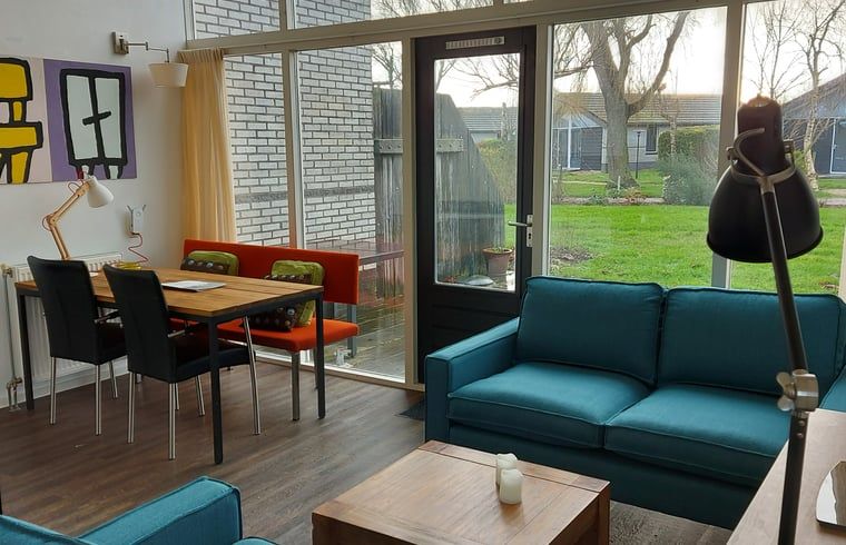 Gemuetliches Wohnzimmer im Ferienhaus in Gaastmeer mit Blick auf den gruenen Garten, ideal fuer Entspannung an den friesischen Seen.