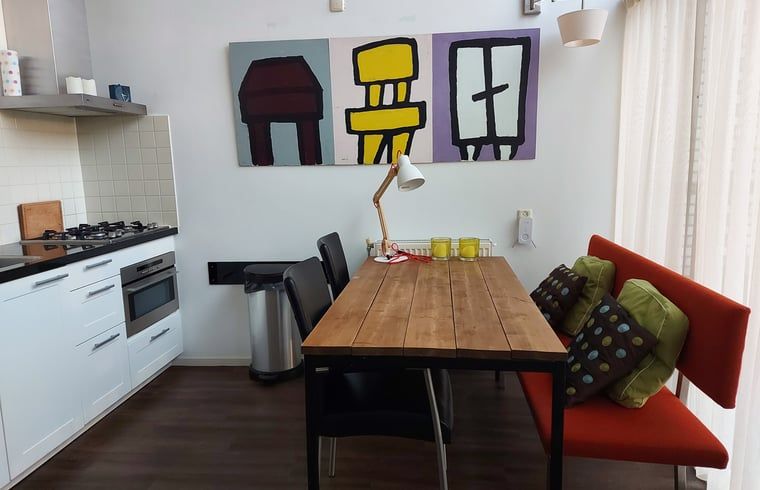 Gemuetlicher Essbereich im Ferienhaus in Gaastmeer, an den friesischen Seen gelegen, mit moderner Kunst und komfortabler Sitzecke.