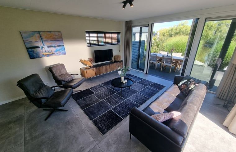 Helles Wohnzimmer im Ferienhaus in Balk mit Blick auf den Garten, ideal zum Entspannen an den friesischen Seen.