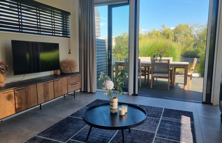 Gemuetlicher Innenbereich des Ferienhauses in Balk mit Zugang zur Terrasse und Blick auf die Natur.