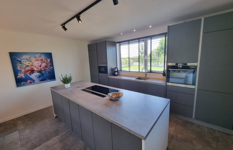 Moderne Kueche im Ferienhaus in Balk mit Blick auf die Landschaft, ideal fuer Kochbegeisterte am Slotermeer.