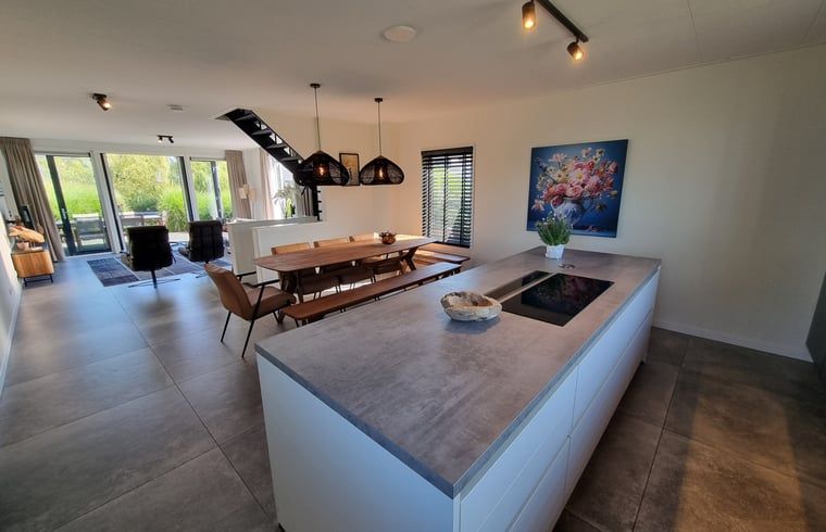 Offene Kueche und Esszimmer im modern eingerichteten Ferienhaus in Balk, in der Naehe des Slotermeers.