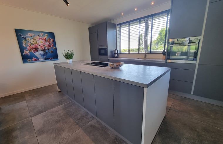 Elegante Kueche im Ferienhaus in Balk mit Insel und Blick auf die Umgebung, perfekt fuer kulinarische Erlebnisse.