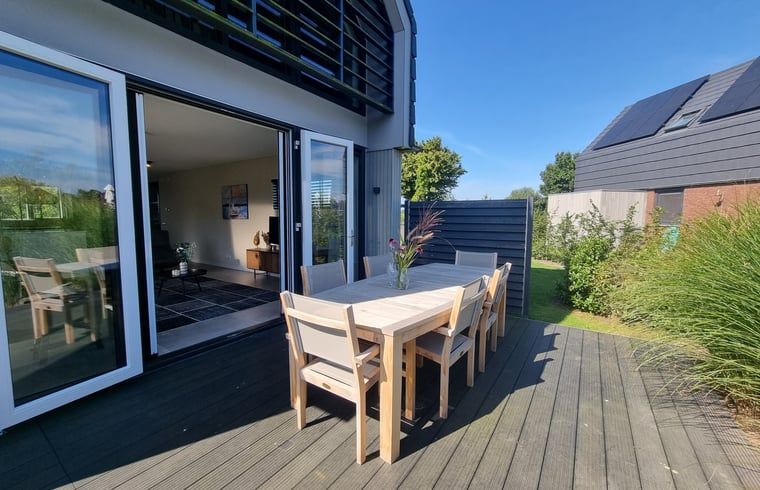 Geraeumige Terrasse des Ferienhauses in Balk mit Holzmoebeln, ideal fuer Mahlzeiten im Freien am Slotermeer.