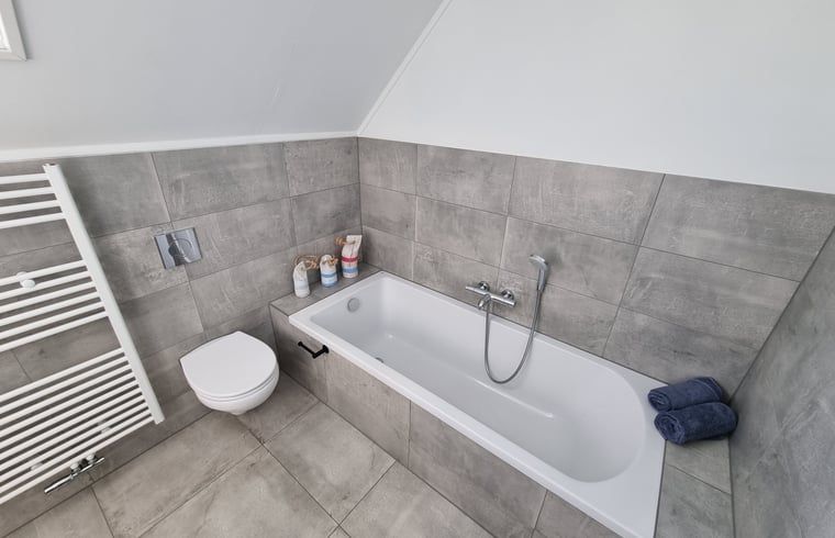 Modernes Badezimmer im Ferienhaus in Balk mit Badewanne und Toilette, ideal fuer Komfort in der Naehe des Slotermeers.