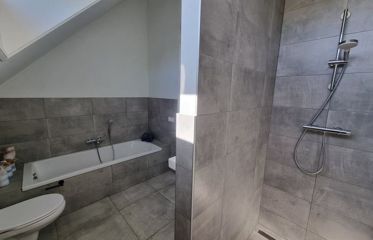 Luxurioeses Badezimmer im Ferienhaus in Balk mit Badewanne und Dusche, ideal zum Entspannen in der Naehe des Slotermeers.