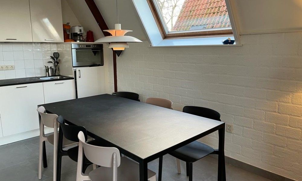 Kitchen and dining area in Bungalow Sneekermeer, Goingarijp, with modern decor and lots of light, ideal for a vacation on the Frisian lakes.