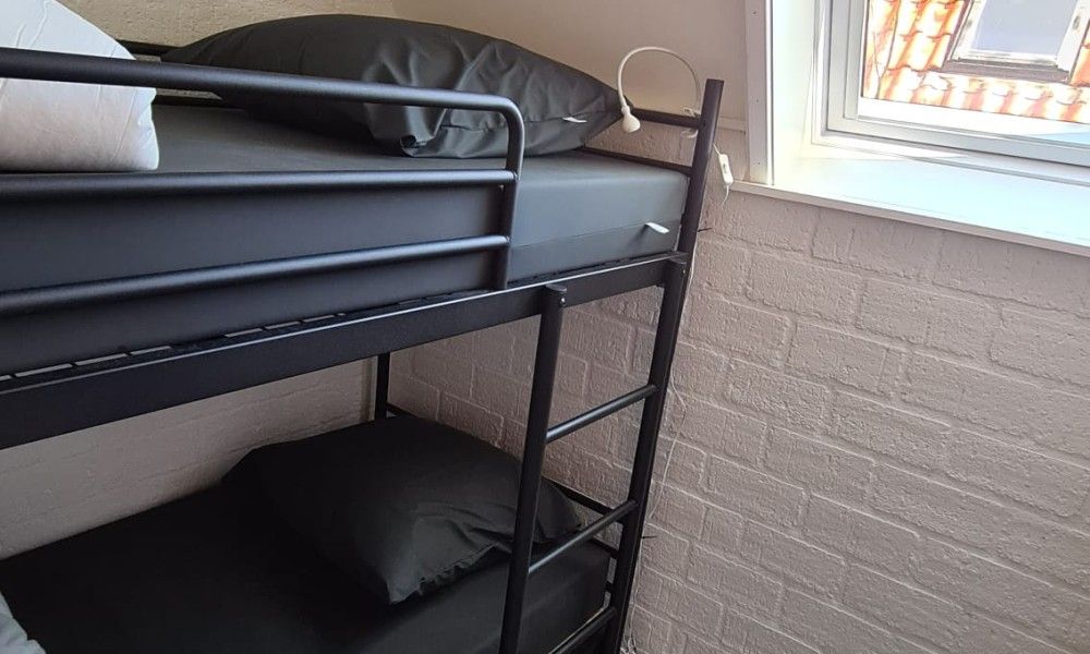 Cozy bedroom with bunk beds in Bungalow Sneekermeer, a vacation home in Goingarijp on the Frisian lakes, ideal for families.