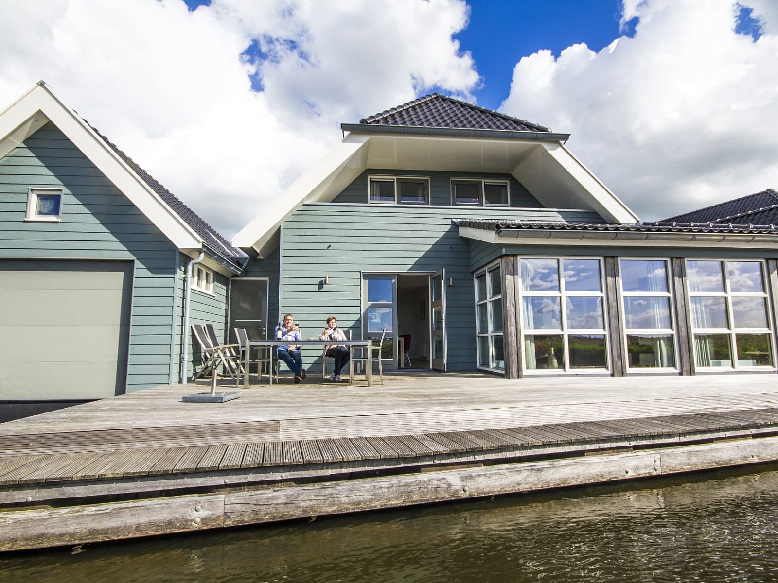 Villa de Goudplevier in Offingawier, Sneekermeer, biedt een ruim terras met uitzicht op het water, ideaal voor ontspanning in de Friese meren.