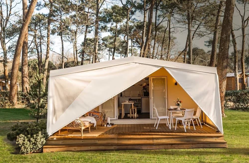 Das Zeltchalet De Kotter in Offingawier am Sneekermeer bietet ein Glamping-Erlebnis mit einer gemuetlichen Veranda, umgeben von der Natur der friesischen Seen.