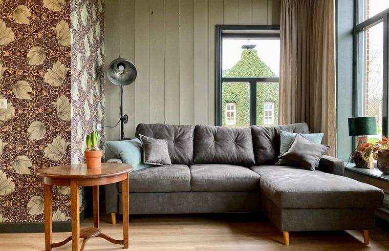 Comfortabele woonkamer in Vakantiehuis in Sumar, Friese meren, met een grote hoekbank.