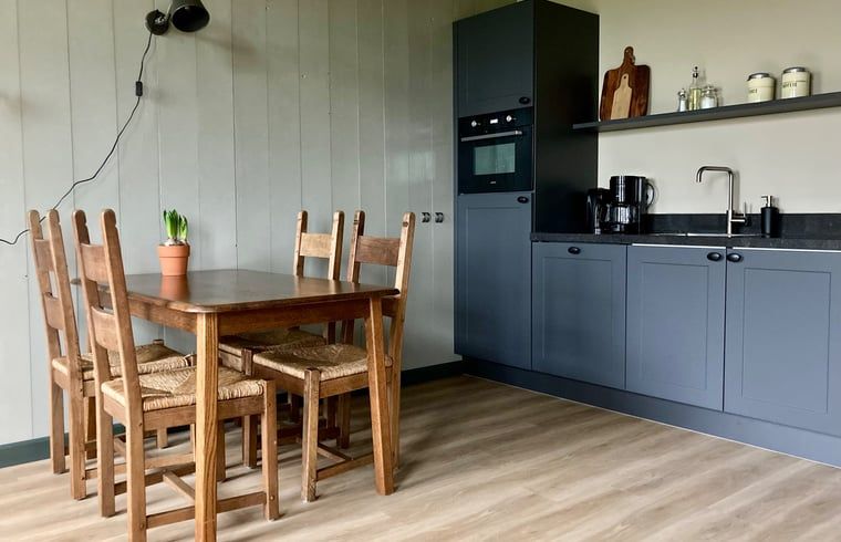 Eetruimte in Vakantiehuis in Sumar, Bergumermeer, met houten tafel en stoelen.