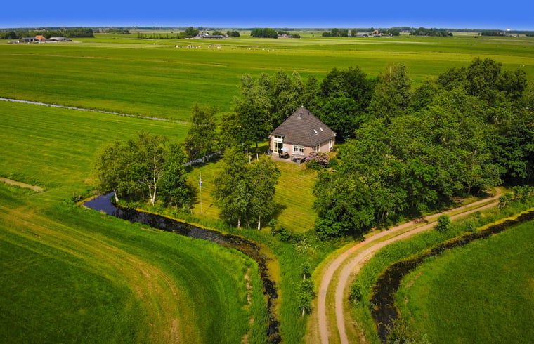 Luftaufnahme von Cottage in De Veenhoop, Ferienhaus umgeben von gruenen Feldern in Princehof, Friesische Seen.