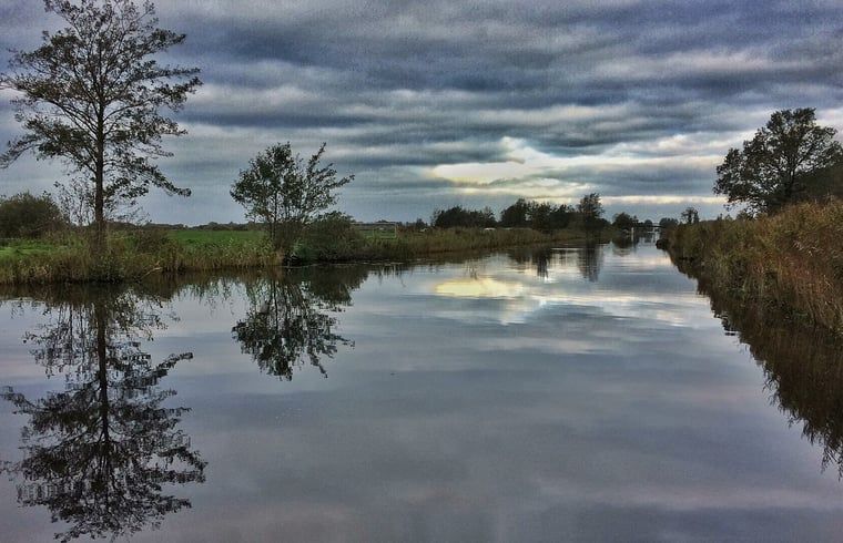 Dramatische Wolkendecke ueber dem Wasser bei Cottage in De Veenhoop, Ferienhaus in Princehof.