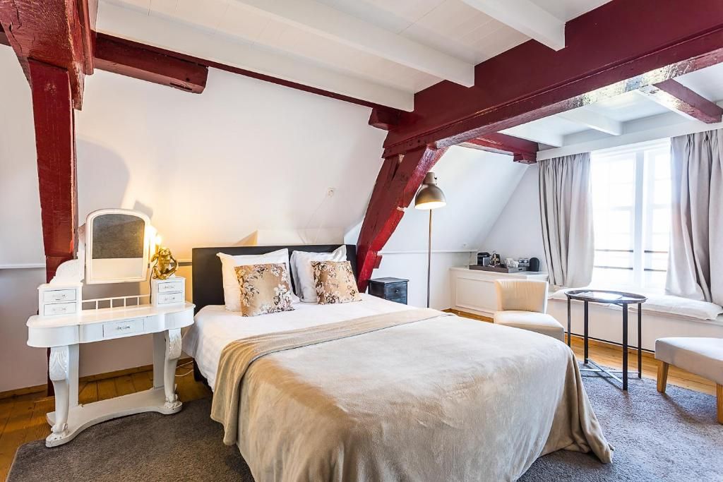 Ruime slaapkamer met houten balken in B&B Parijs aan de Kaai, Middelburg.