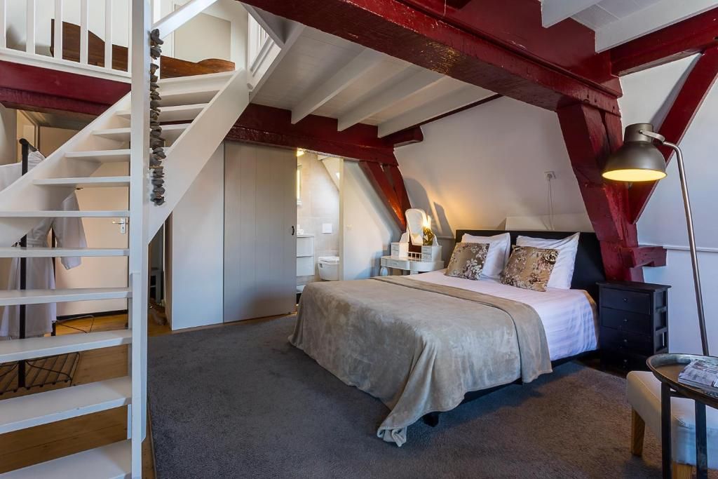 Slaapkamer met trap naar zolder in B&B Parijs aan de Kaai, Zeeland, knus en stijlvol.