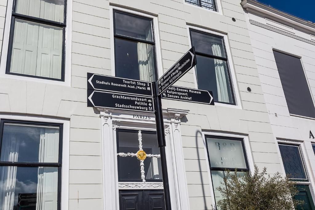 Historische gevel met straatnaamborden bij B&B Parijs aan de Kaai, Zeeland.