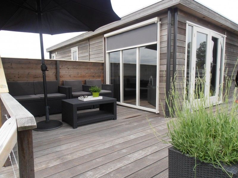 Veranda van Vakantiewoningen Oostmahorn in Lauwersmeer met comfortabel zitgedeelte en uitzicht op de Friese meren.