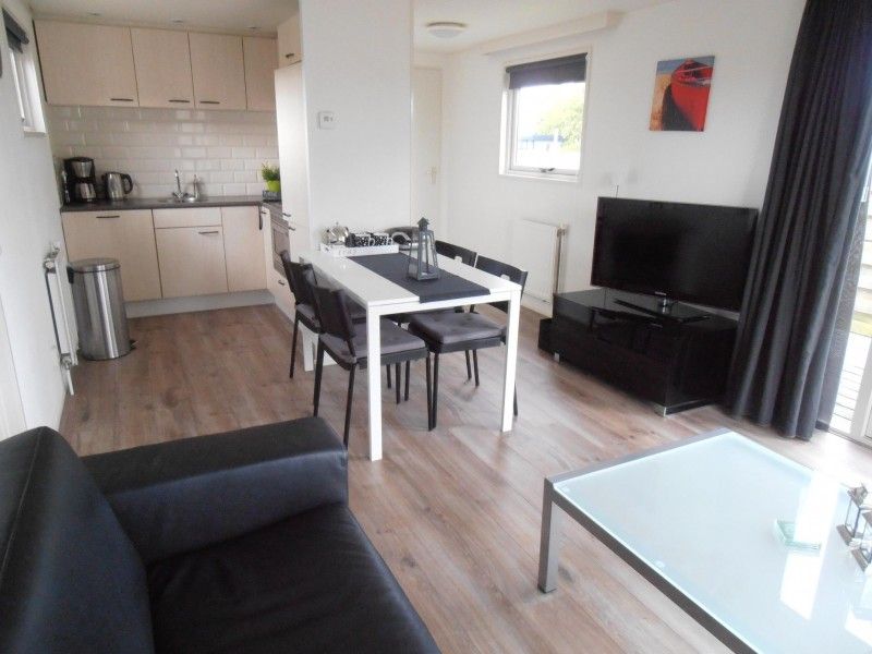 Gezellige eet- en woonkamer in chalet Vakantiewoningen Oostmahorn, perfect voor ontspannen avonden in Lauwersmeer.