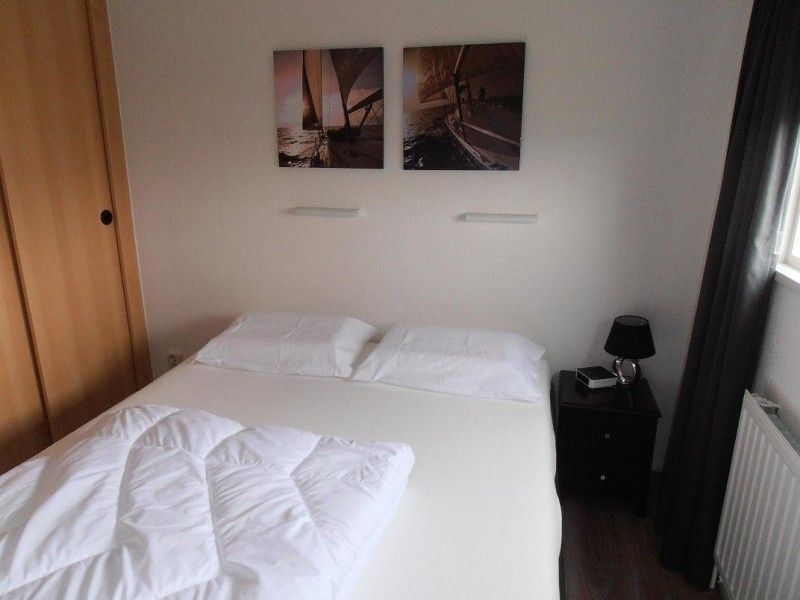 Slaapkamer met comfortabel tweepersoonsbed in Vakantiewoningen Oostmahorn, ideaal voor een goede nachtrust in Friese meren.