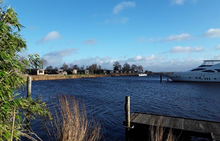 Blick auf das Wasser beim Ferienhaus in Oostmahorn, Ferienhaus am Lauwersmeer, friesische Seen mit ruhiger Natur und Anlegestelle fuer Boote.