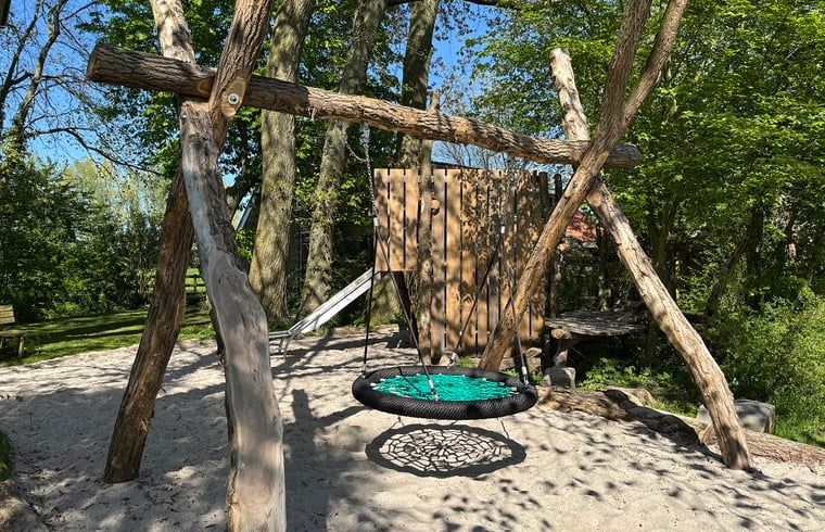 Schaukeln Sie auf dem Spielplatz von Cottage in Kollumerpomp, einem Ferienhaus in Kollumerpomp, umgeben von Gruenflaechen.