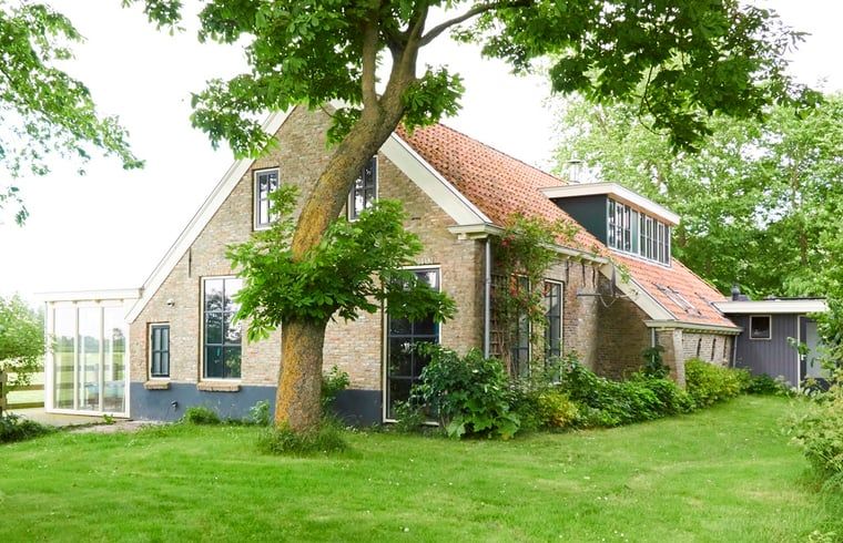 Vacation home in Kollumerpomp, located in the green nature of Lauwersmeer, offers a charming exterior with traditional Frisian architecture.