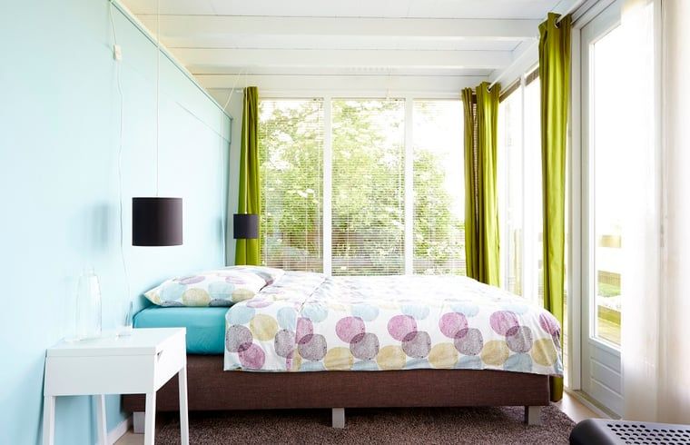 Bright bedroom in Holiday Home in Kollumerpomp, Lauwersmeer, with colorful accents and large windows with views.