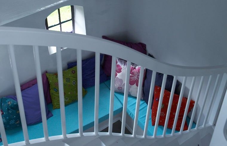 Stairs with colorful sitting area in Holiday home in Kollumerpomp, Lauwersmeer, ideal for relaxation and views.
