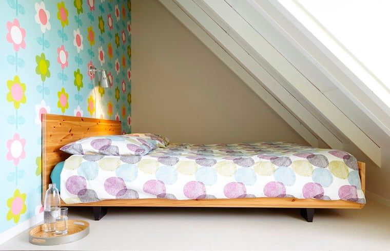 Attractive bedroom in Holiday Home in Kollumerpomp, Lauwersmeer, with floral design and warm furnishings.