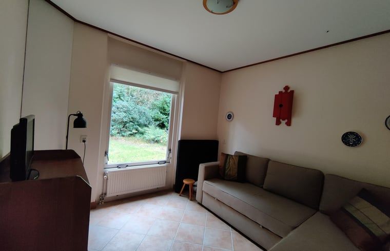 Gezellige zithoek in Vakantiehuis in Spier met uitzicht op de tuin in Drenthe.