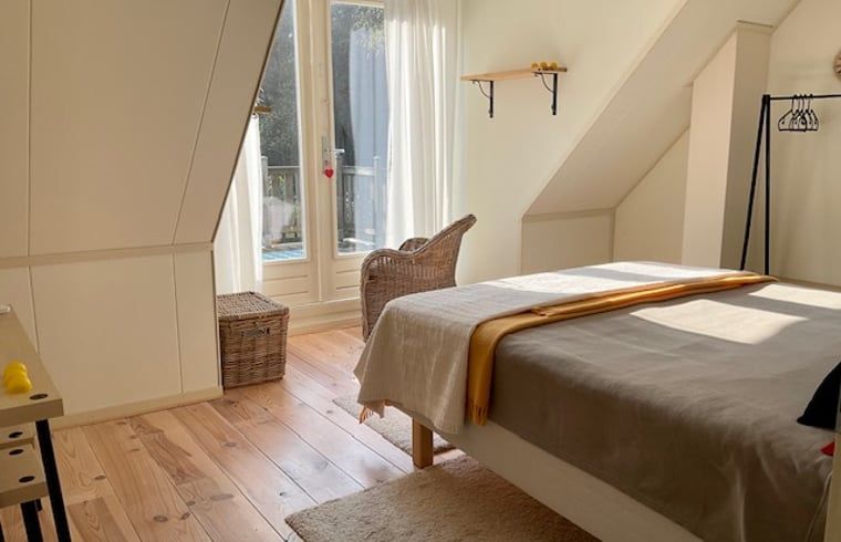 Slaapkamer met balkon in Vakantiehuis in Spier, biedt rust en uitzicht op de natuur van Drenthe.