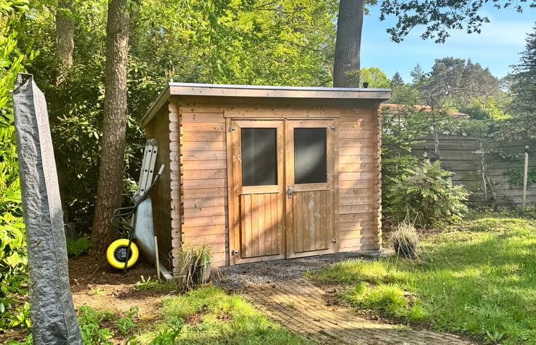 Houten schuurtje in de tuin van Vakantiehuis in Spier, biedt extra opslagruimte in Drenthe.