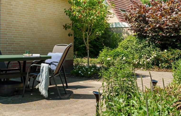 Terras met zitje in de tuin van Vakantiehuis in Schoonloo, Midden Drenthe.
