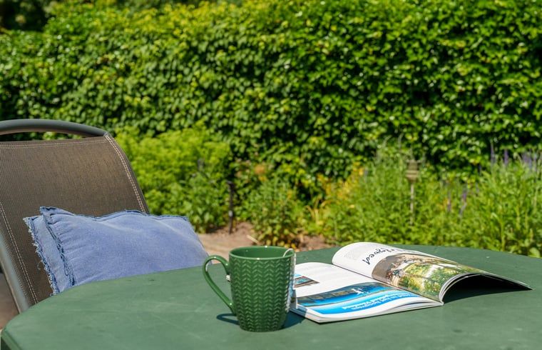 Tuinmeubilair in de groene omgeving van Vakantiehuis in Schoonloo, Midden Drenthe.