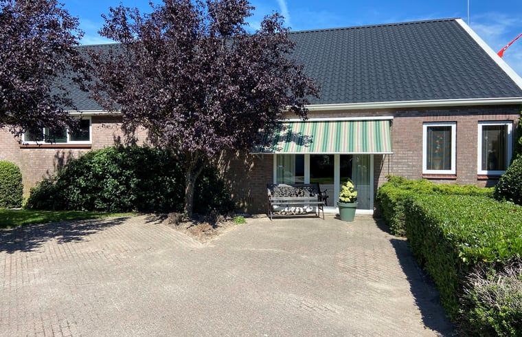 Ferienhaus in Beilen, Zentral-Drenthe, mit gemuetlichem Vorgarten und Bank zum Entspannen.