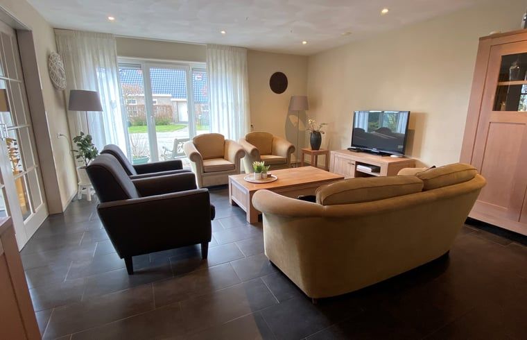 Gemuetliches Wohnzimmer im Ferienhaus in Beilen, Zentral-Drenthe, mit bequemen Sitzgelegenheiten.