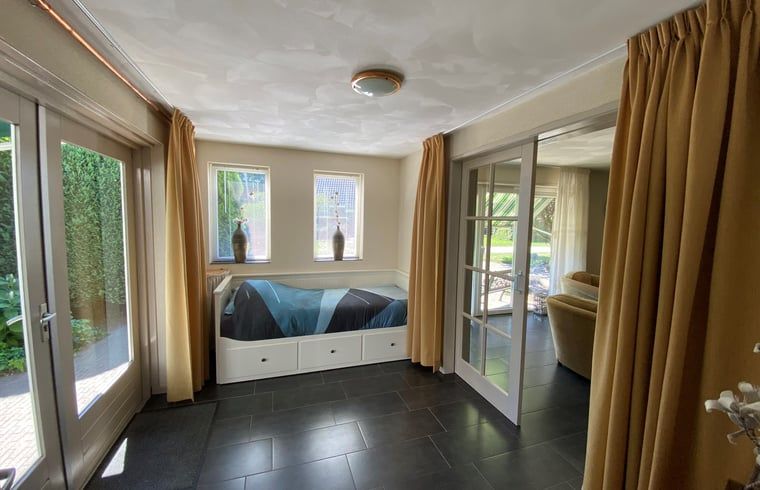 Gemuetliche Ecke mit Bett im Ferienhaus in Beilen, Zentral-Drenthe, fuer erholsame Naechte.