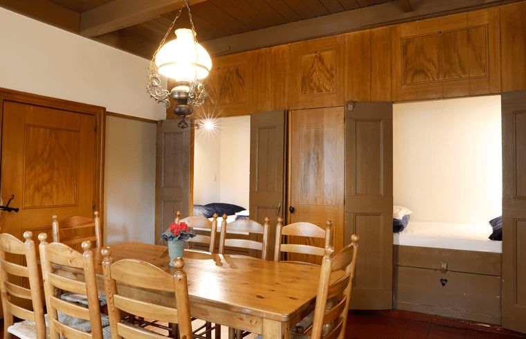 Dining room in vacation home in Orvelte, Central Drenthe, with wooden furniture and mood lighting.