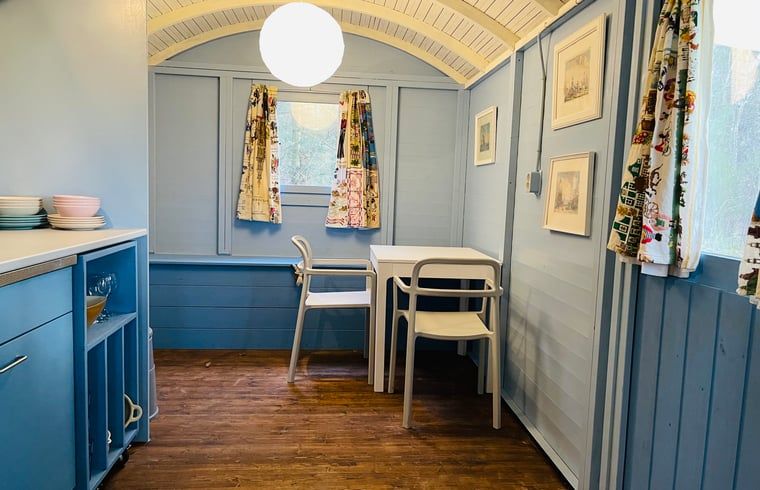 Cozy indoor area of Huisje in Papenvoort, vacation home in Central Drenthe, with wooden interior and cozy sitting area.