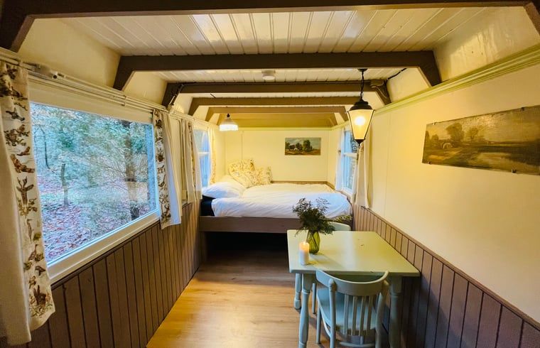 Cozy indoor area of Huisje in Papenvoort, a vacation home in Central Drenthe, with cozy dining area and views of nature.