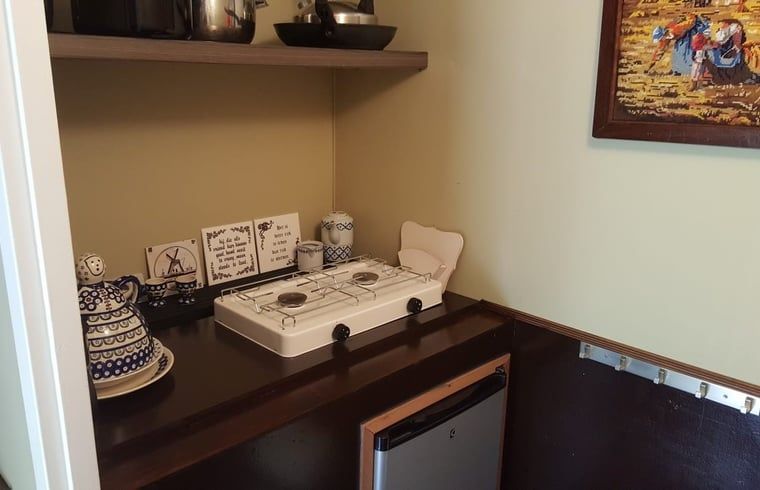 Cozy kitchenette in Cottage in Papenvoort, cottage in Central Drenthe, with stove and refrigerator, ideal for a relaxing stay.