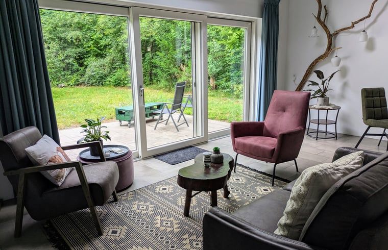 Lichte woonkamer van Vakantiehuis in Westerbork met uitzicht op de tuin, ideaal voor ontspanning in Midden Drenthe, Drenthe.