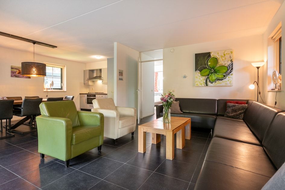 Gemuetliches Wohnzimmer der Zandduin Villa mit Sauna 10 in Hooghalen, Zentral-Drenthe. Gemuetliche Sitzecke und moderne Kueche fuer einen entspannten Aufenthalt.