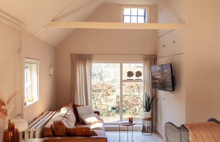 Lichte woonkamer met uitzicht in Vakantiehuisje in Hooghalen, ontspannen sfeer in Midden Drenthe, Drenthe.