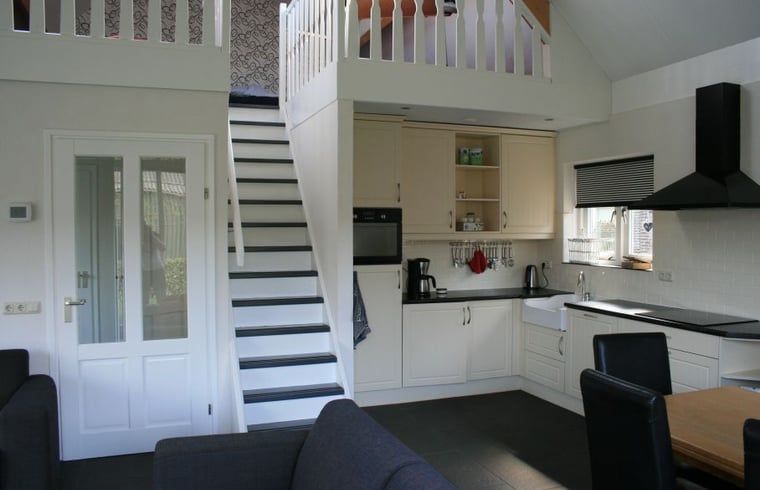 Open keuken met trap naar bovenverdieping in Huisje in Eesergroen, vakantiehuis in Midden Drenthe.