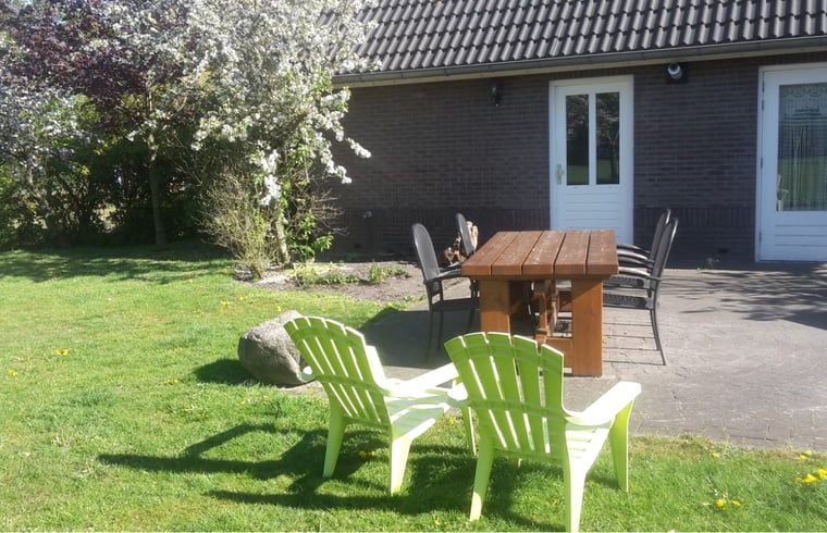 Tuinmeubilair op het gras bij Huisje in Eesergroen, vakantiehuis in Midden Drenthe.