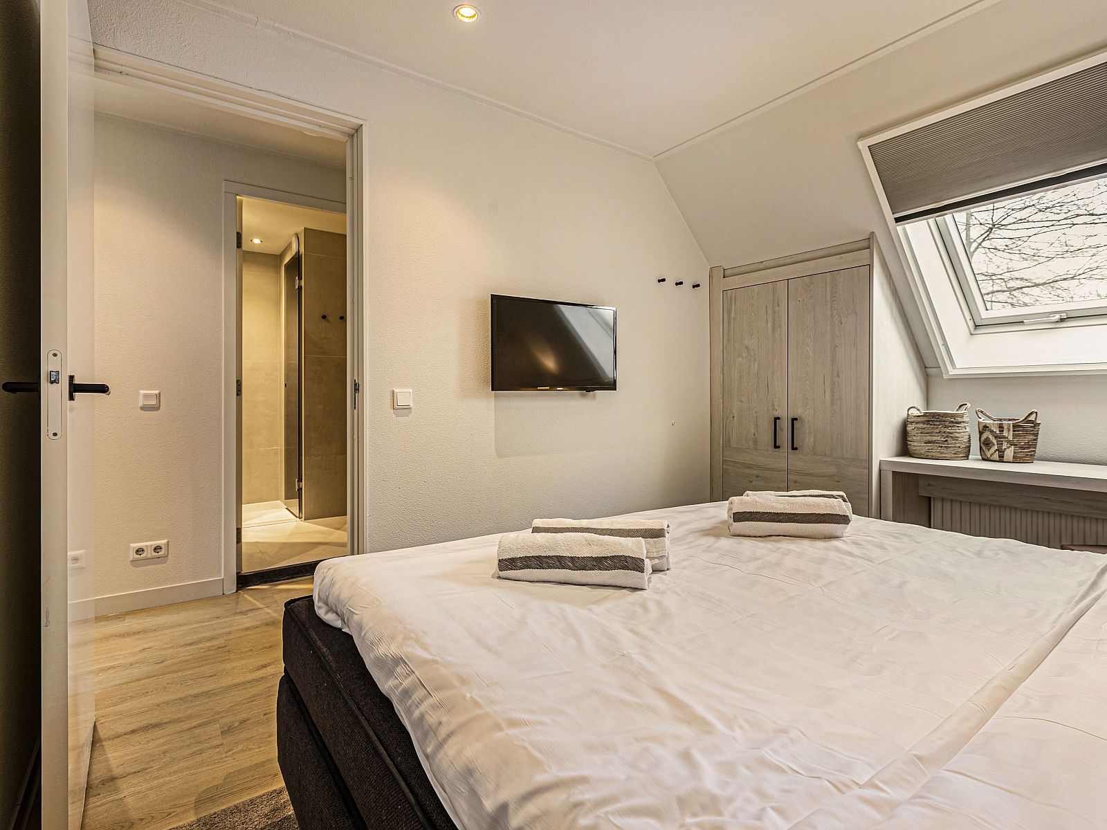 Moderne badkamer in Hof van Saksen 18-persoons boerderij, Nooitgedacht, Drenthe met inloopdouche en ronde spiegel.